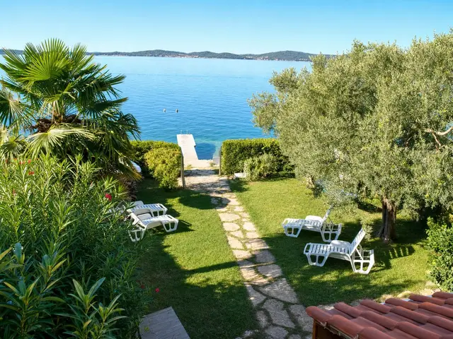 Garten des Ferienhauses mit direktem Zugang zum Meer und Steg