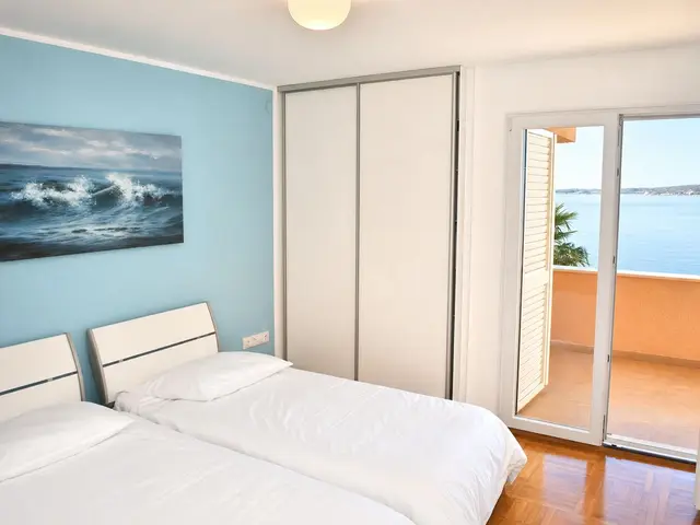 Schlafzimmer mit Doppelbett und Blick aufs Wasser